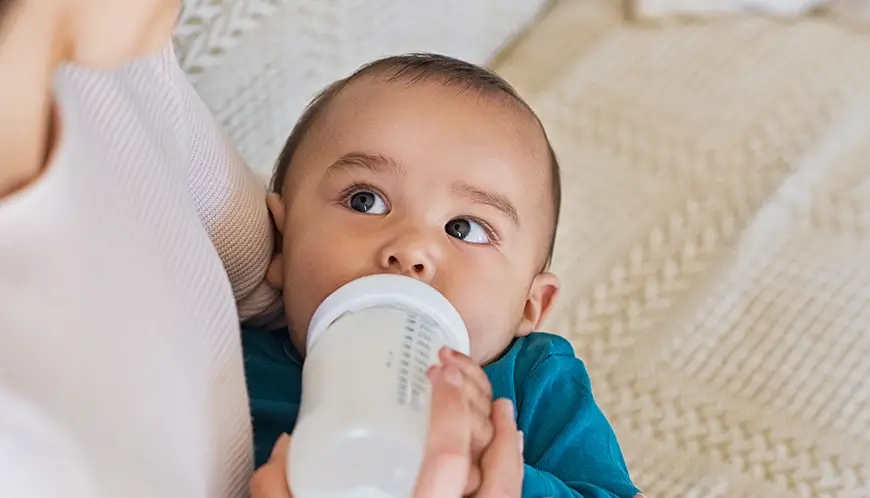 Ibu memberikan asupan nutrisi aman untuk bayi menggunakan air murni.